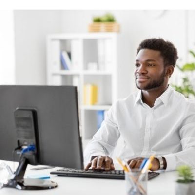 man sitting in front of computer monitor