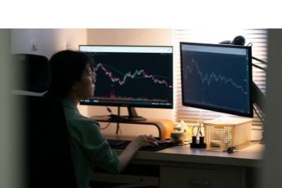 man sitting in front of two computer monitors