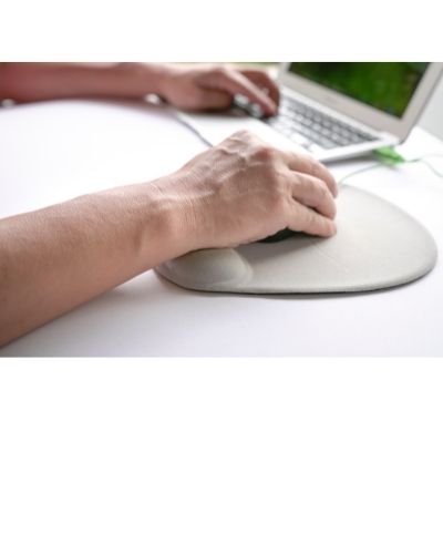 person's hand resting on a mouse pad with wrist pad. Left hand rests on a keyboard.