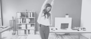 woman standing and stretching in office