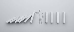 sticks are lined up vertically. there is a drawing of a human figure holding falling blocks to its left. on its right, the blocks remain standing.